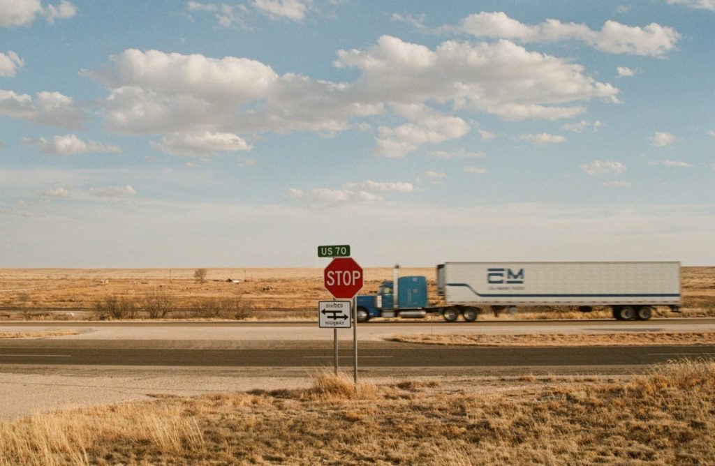 Semi-truck on a road in a vast dry landscape