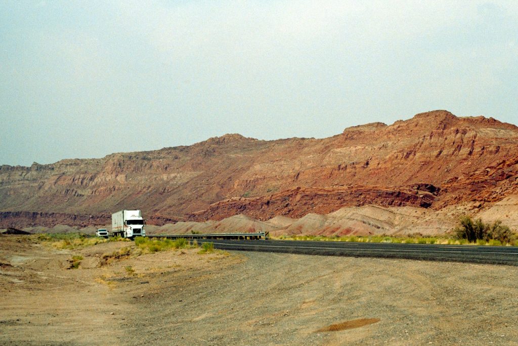 Semi truck traveling a highway through rocky hills