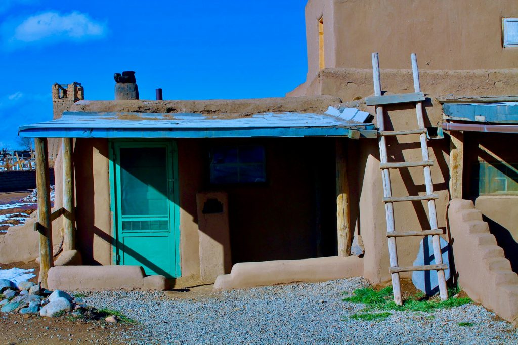 Adobe wall with a classic Taos blue door in Taos, New Mexico