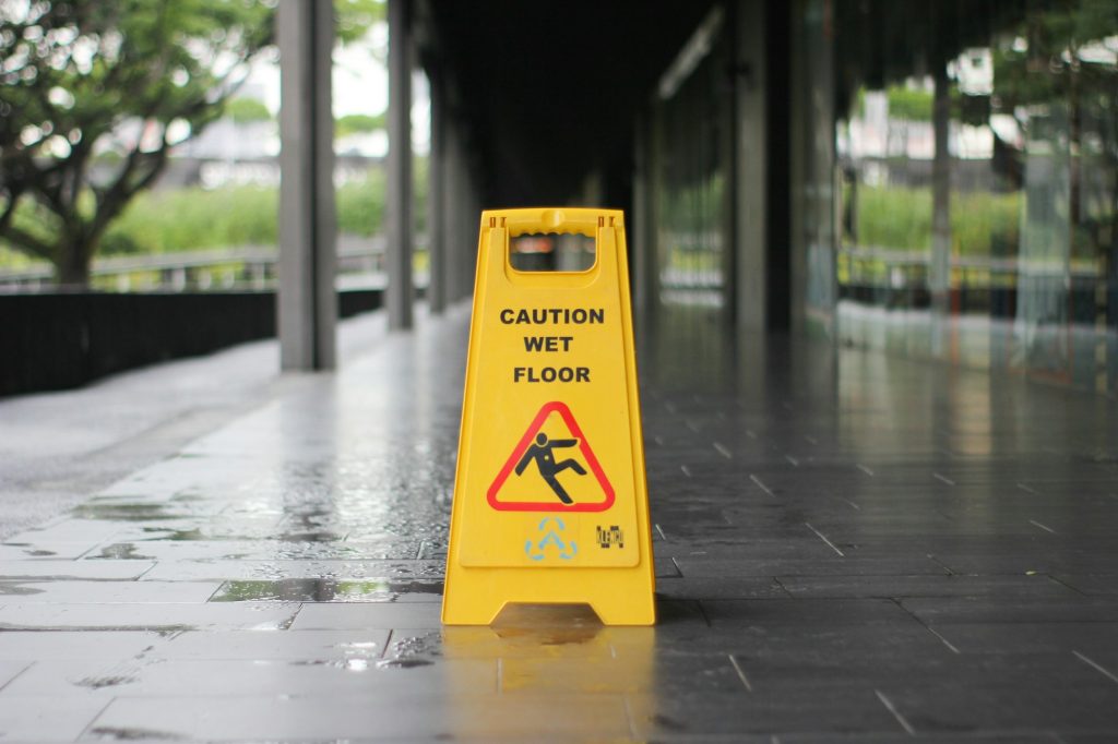 Yellow caution wet floor sign on a wet walkway